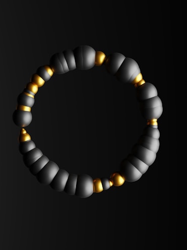 Minimalist bracelets featuring matte charcoal beads with subtle champagne accents