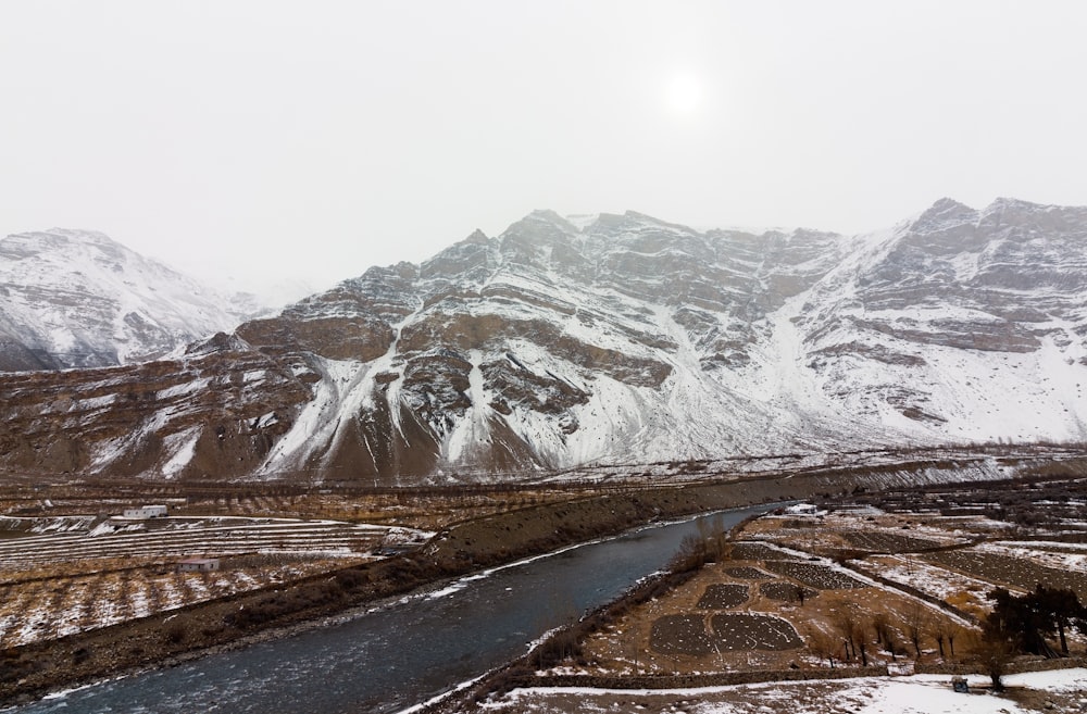 a snow covered mountain range with a river running through it