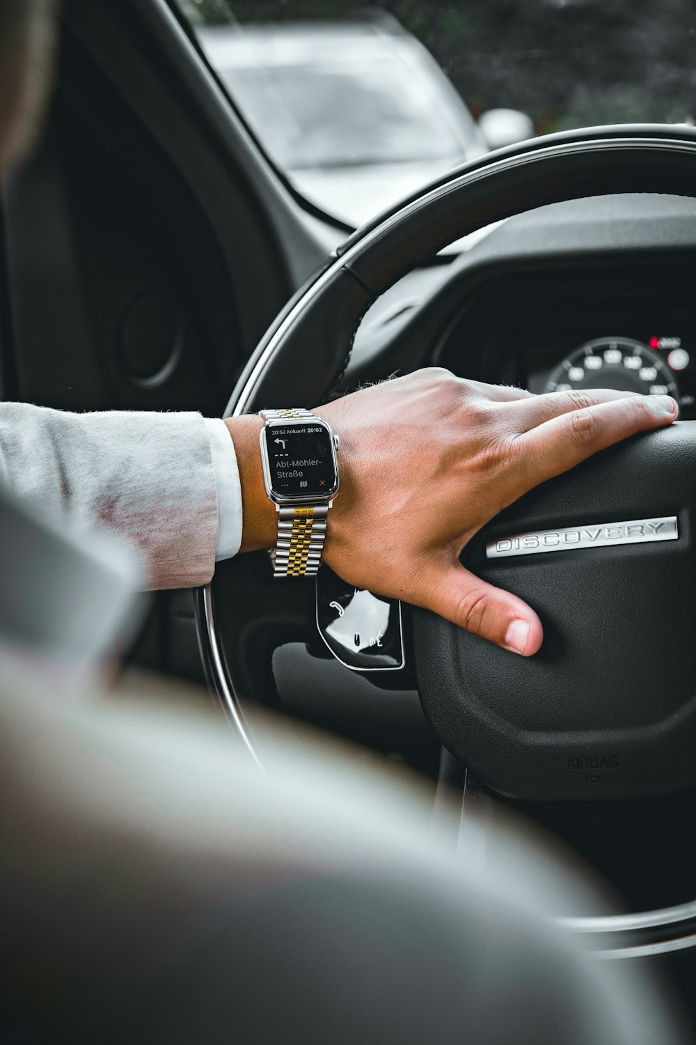 a person's hand on the steering wheel of a car