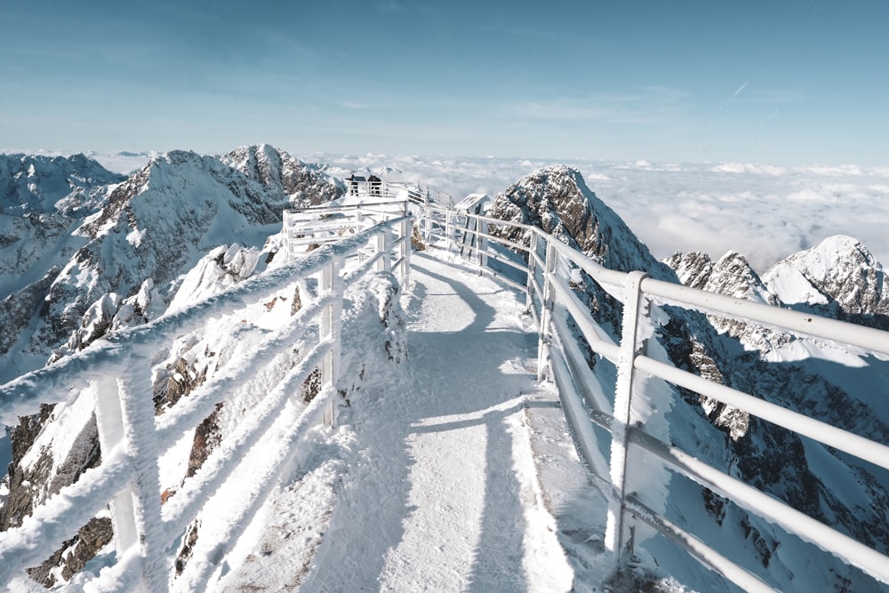 uma montanha coberta de neve com uma cerca branca