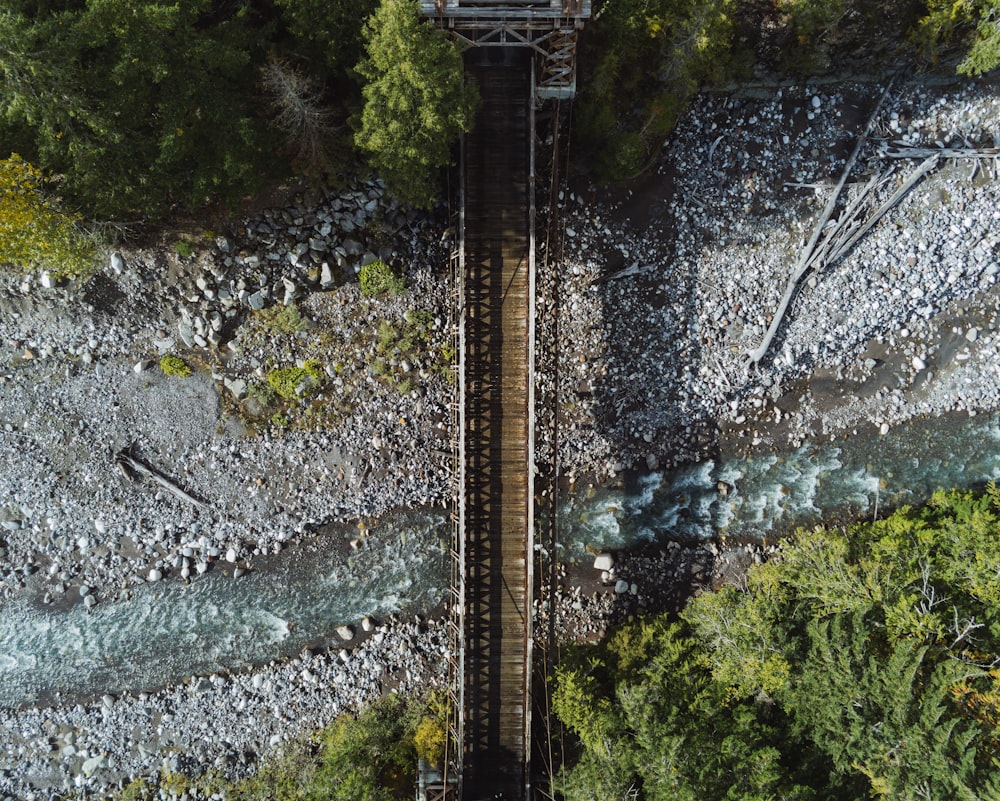 an aerial view of a train crossing a bridge over a river