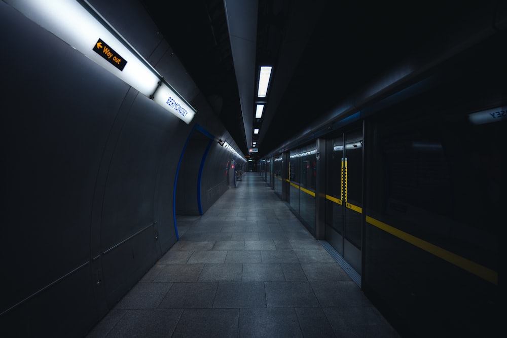 a long dark hallway with yellow and blue lights