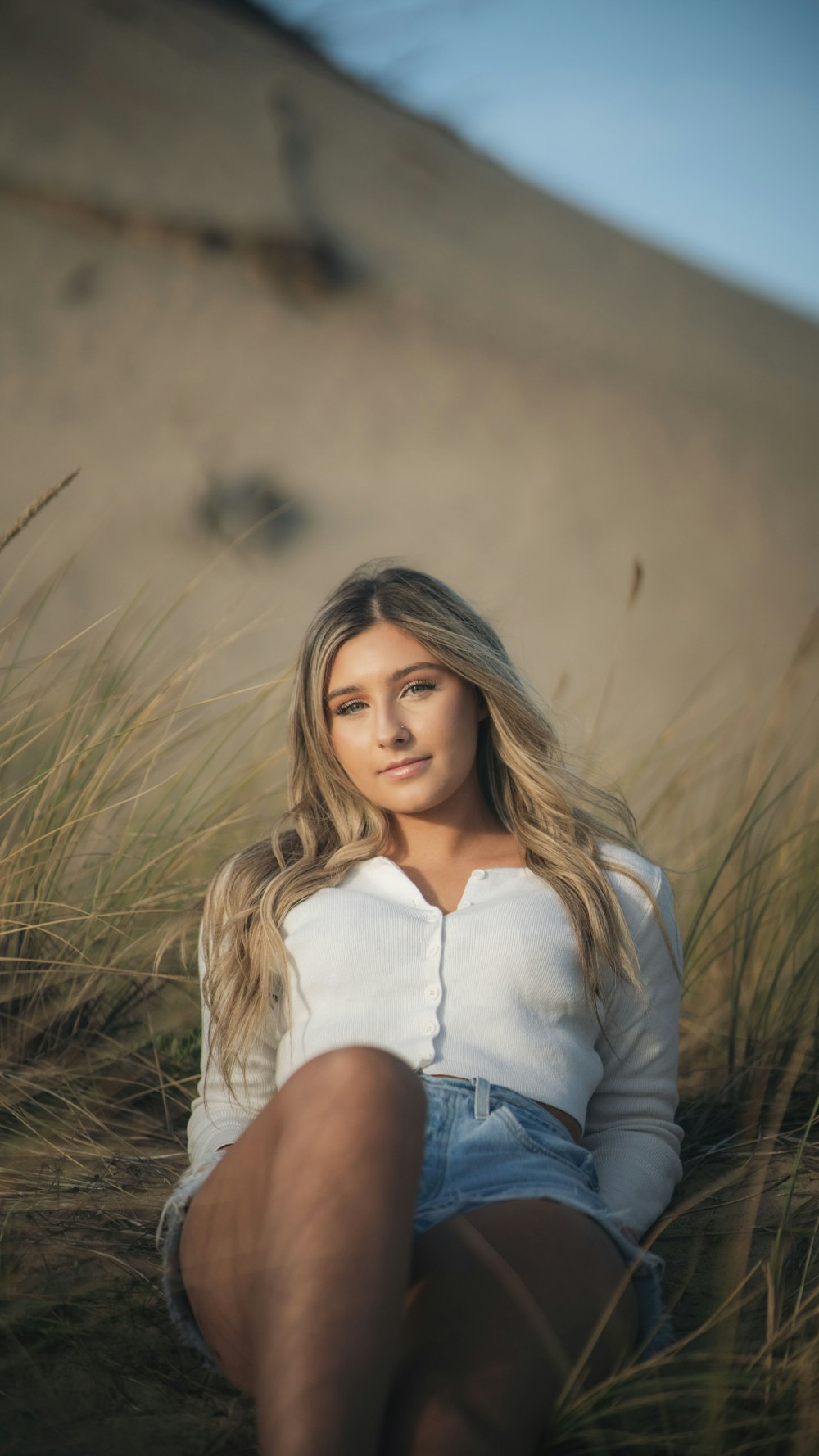 a woman sitting in a field of tall grass