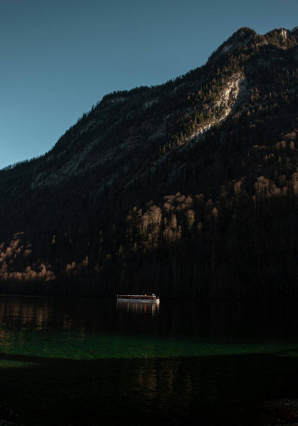 a boat on a lake in front of a mountain