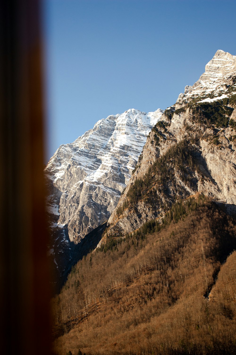 a view of a snowy mountain from a train window