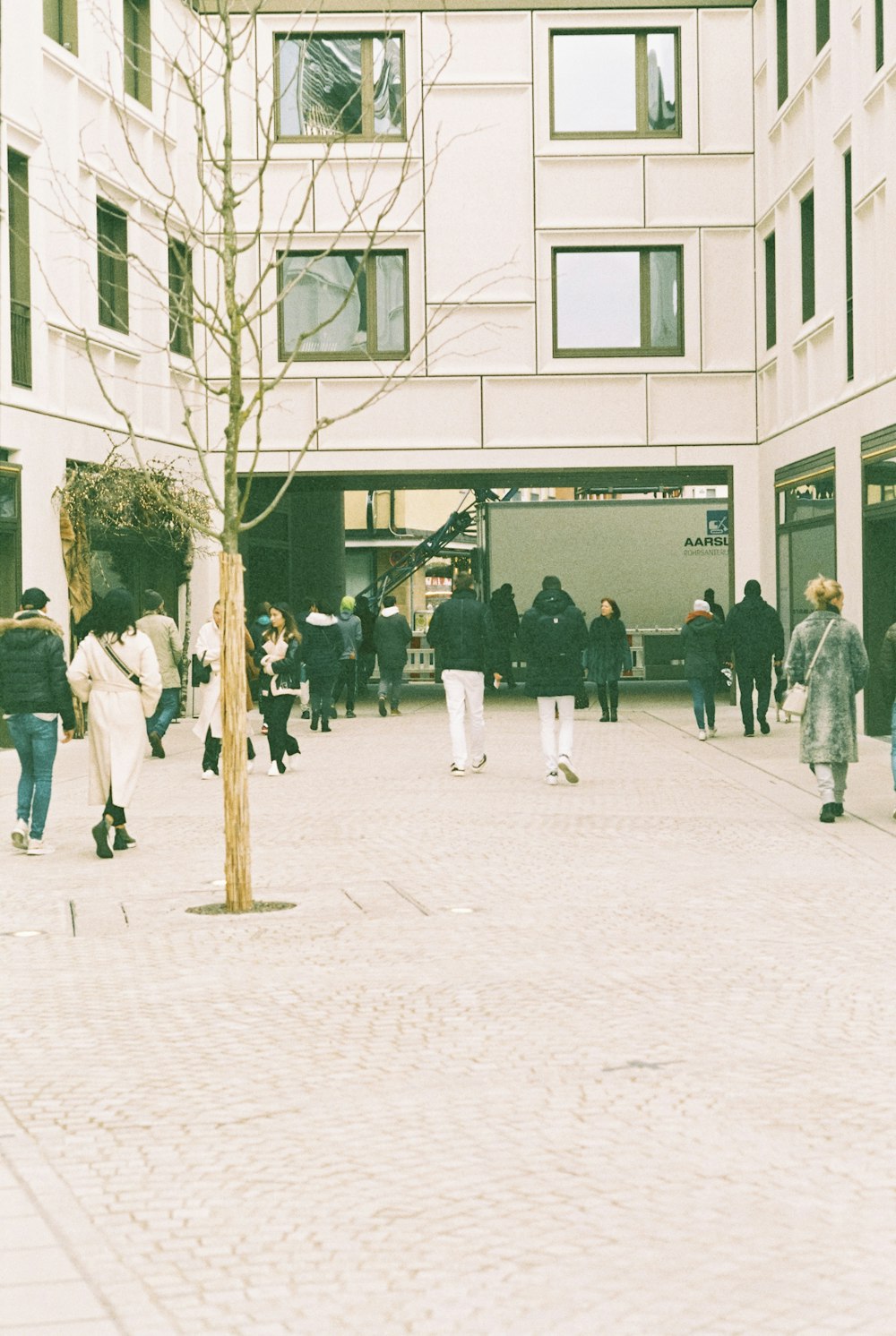 a group of people walking around a building