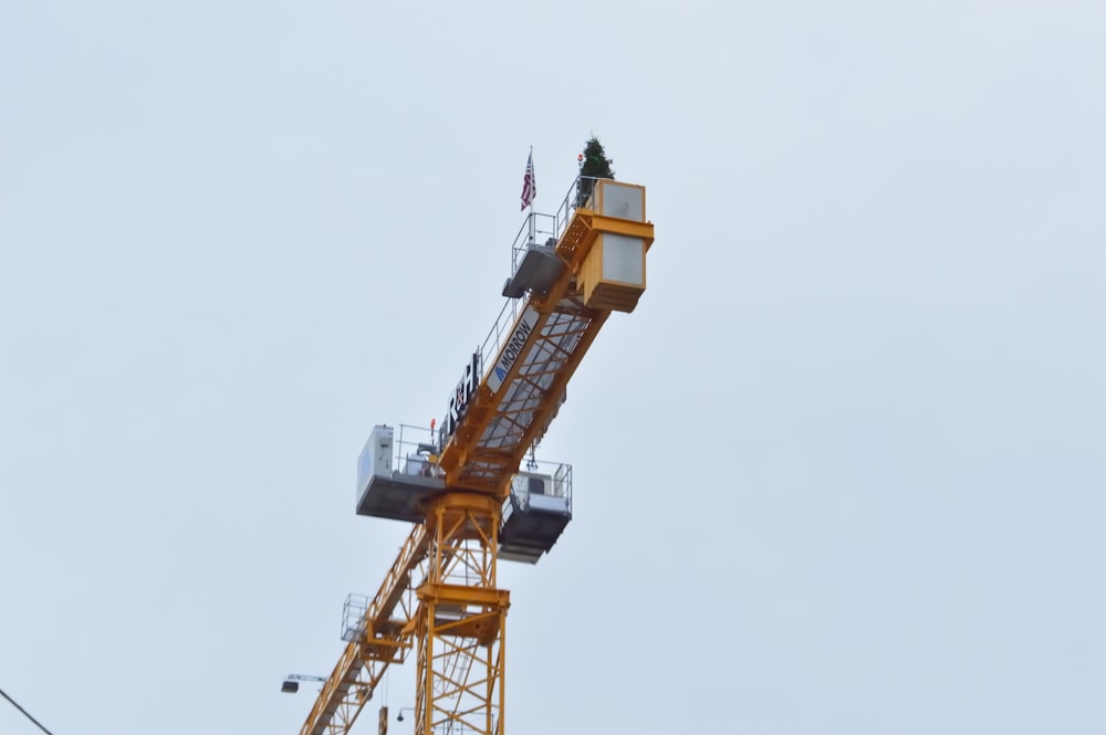 a yellow crane with a clock on top of it
