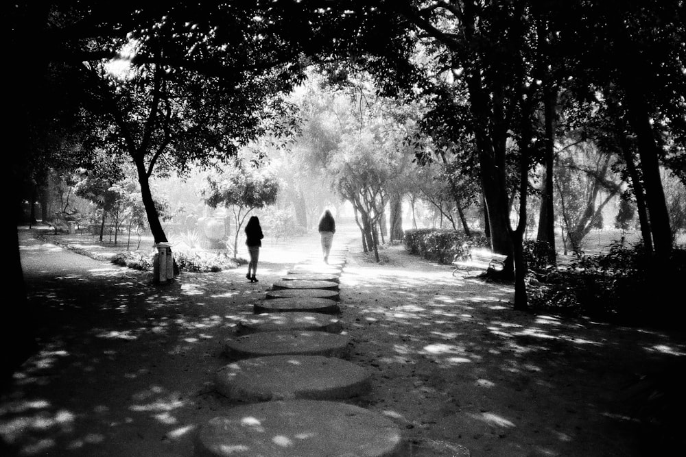two people walking down a path in a park