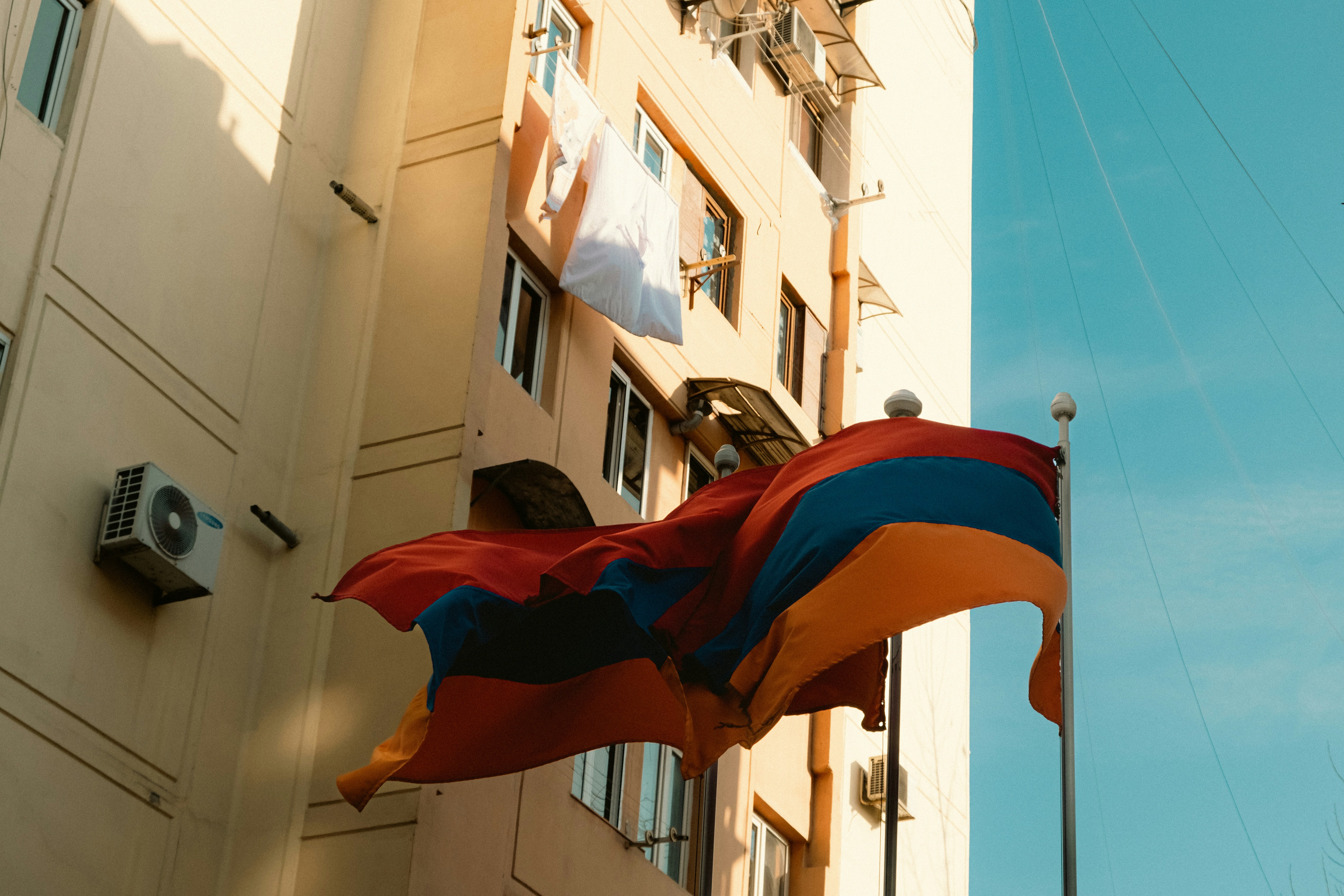 Una bandiera che sventola nel vento accanto a un edificio alto