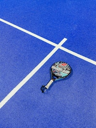 a tennis racket on a blue tennis court