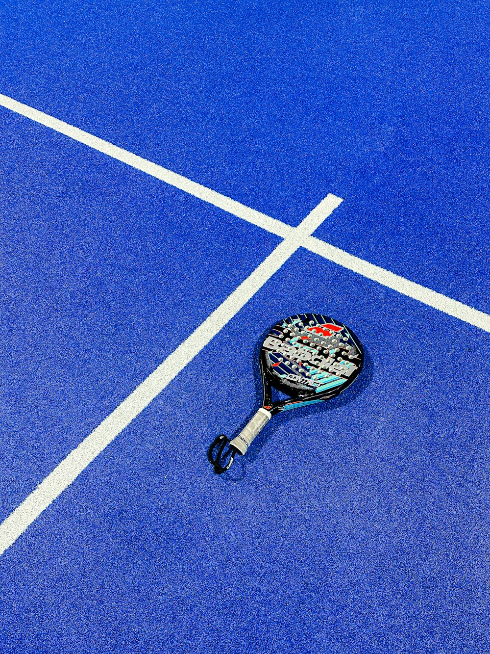 a tennis racket on a blue tennis court