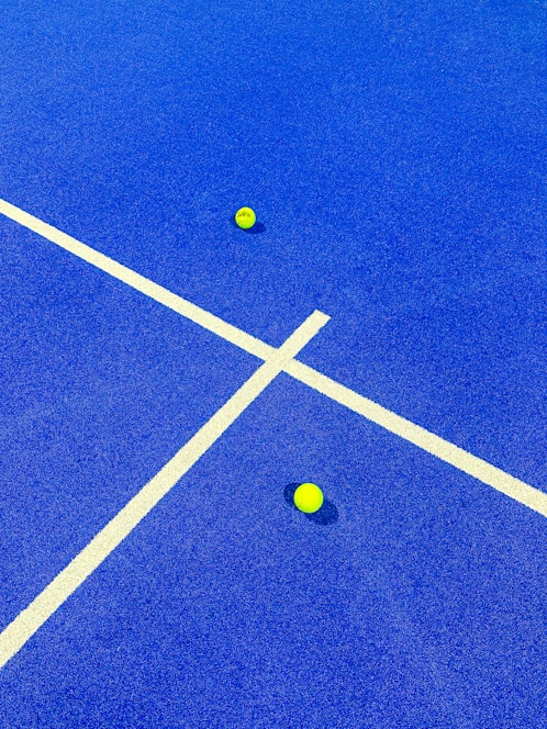 two tennis balls on a blue tennis court