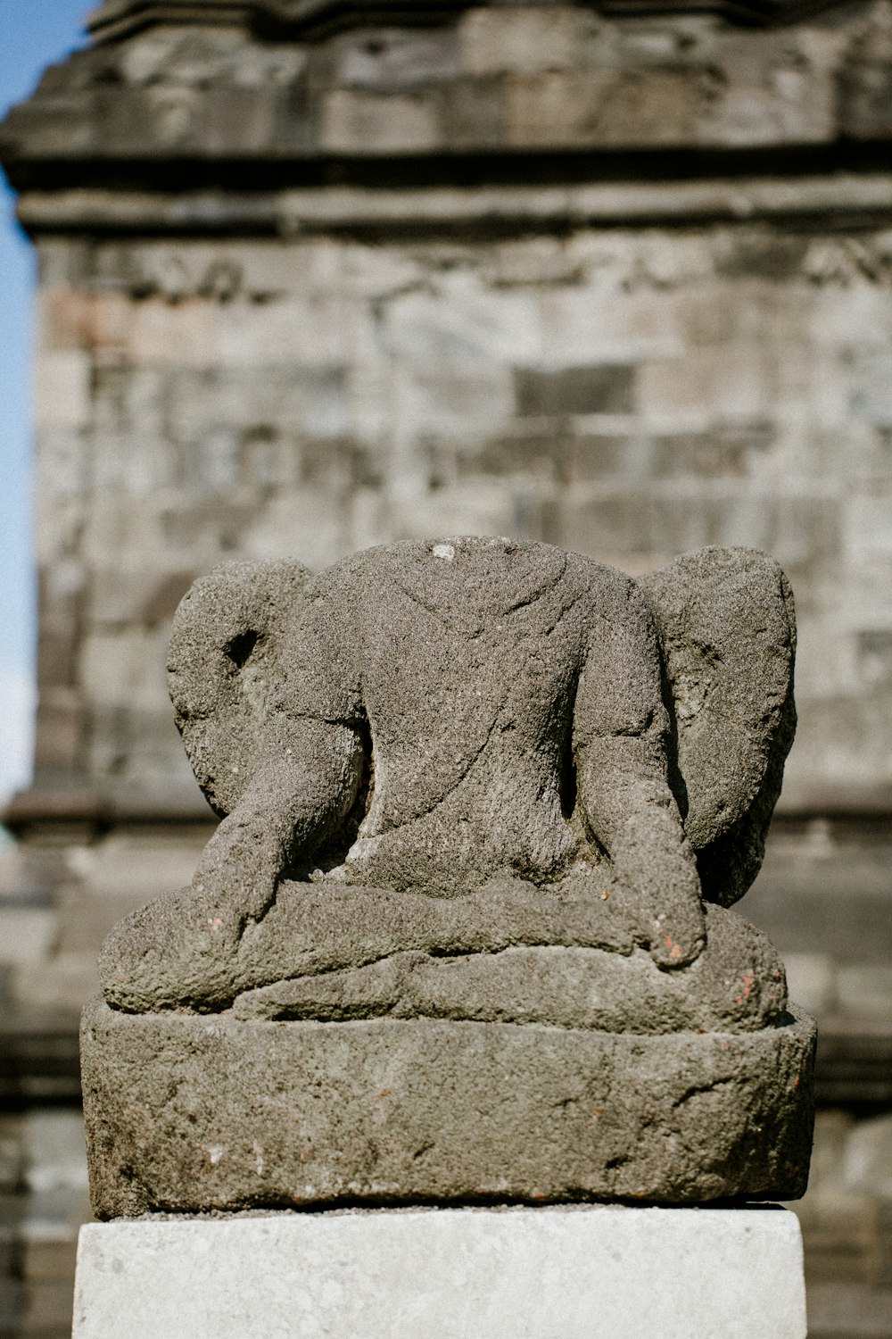 a stone statue of a bear on a pedestal