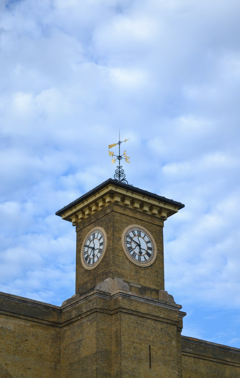 a clock tower with a weather vane on top