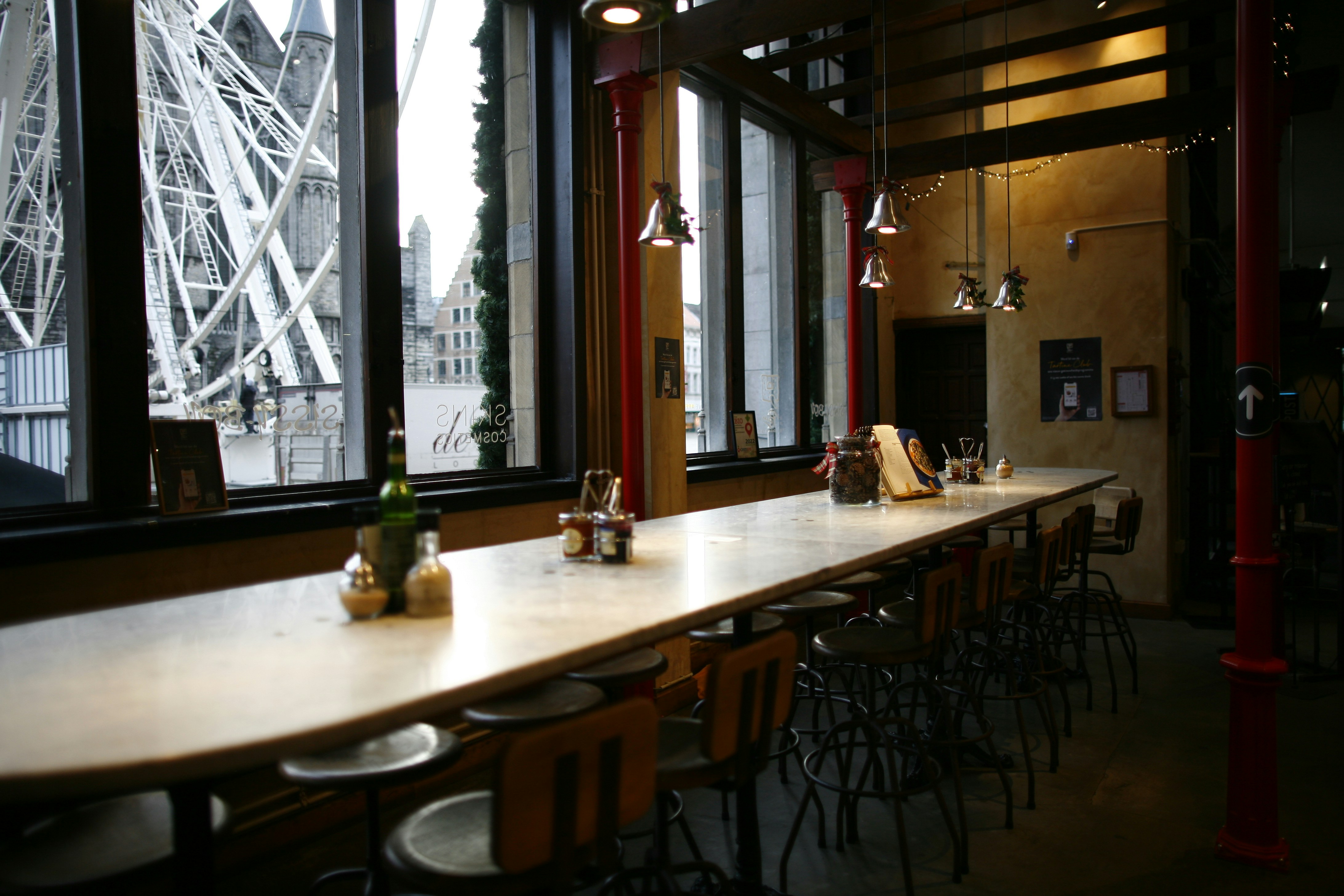 a long table in a restaurant with a ferris wheel in the background