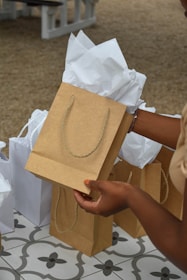 a woman is holding a brown paper bag