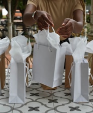 a woman holding two bags of white paper