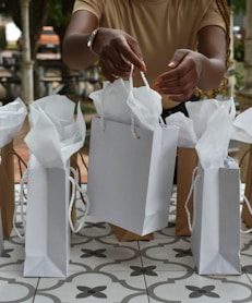 a woman holding two bags of white paper