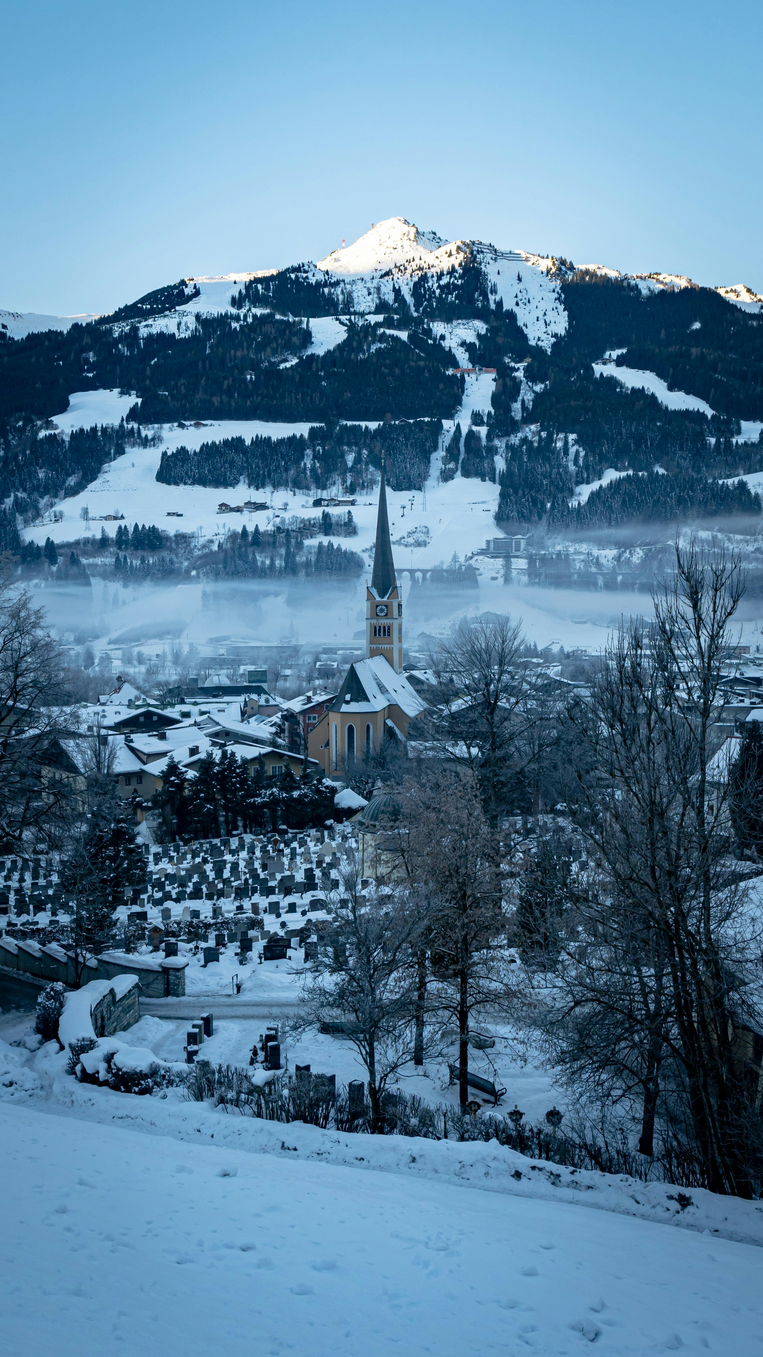 Ein schneebedeckter Berg mit einer Kirche im Vordergrund