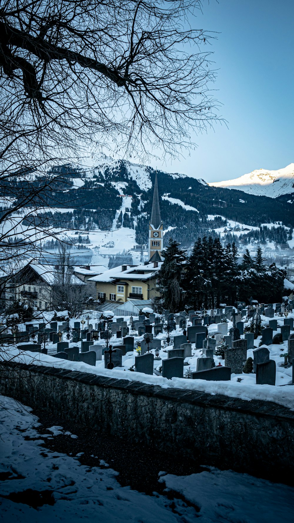 a cemetery in the snow with a church in the background