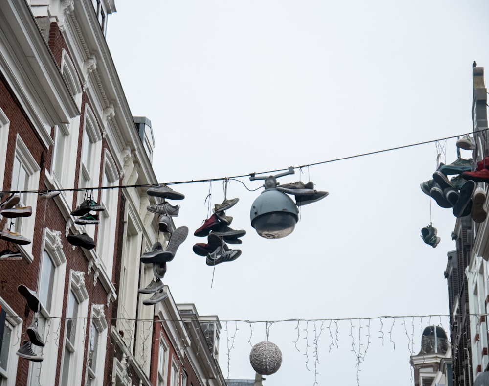 a bunch of shoes hanging from a line next to a building