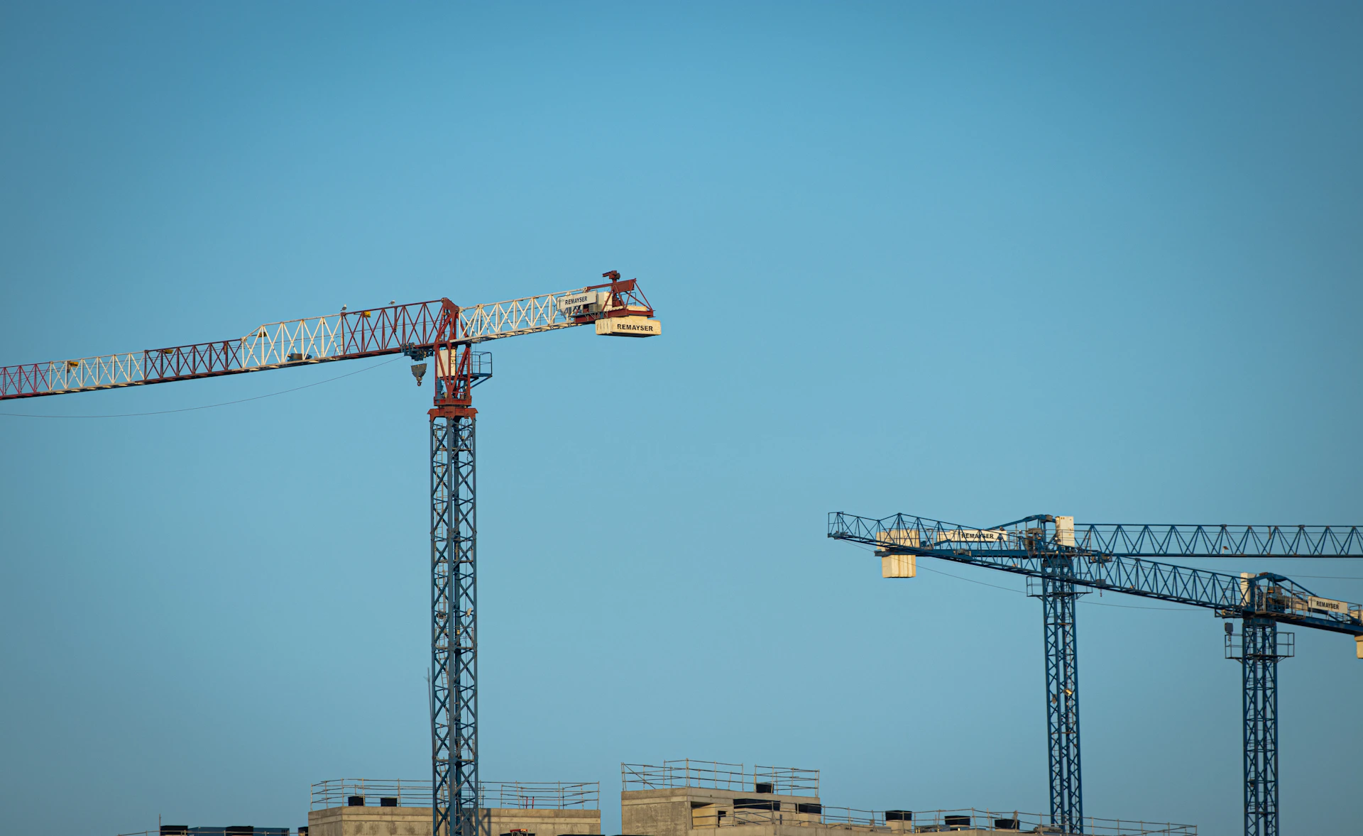a large crane sitting next to a building under a blue sky