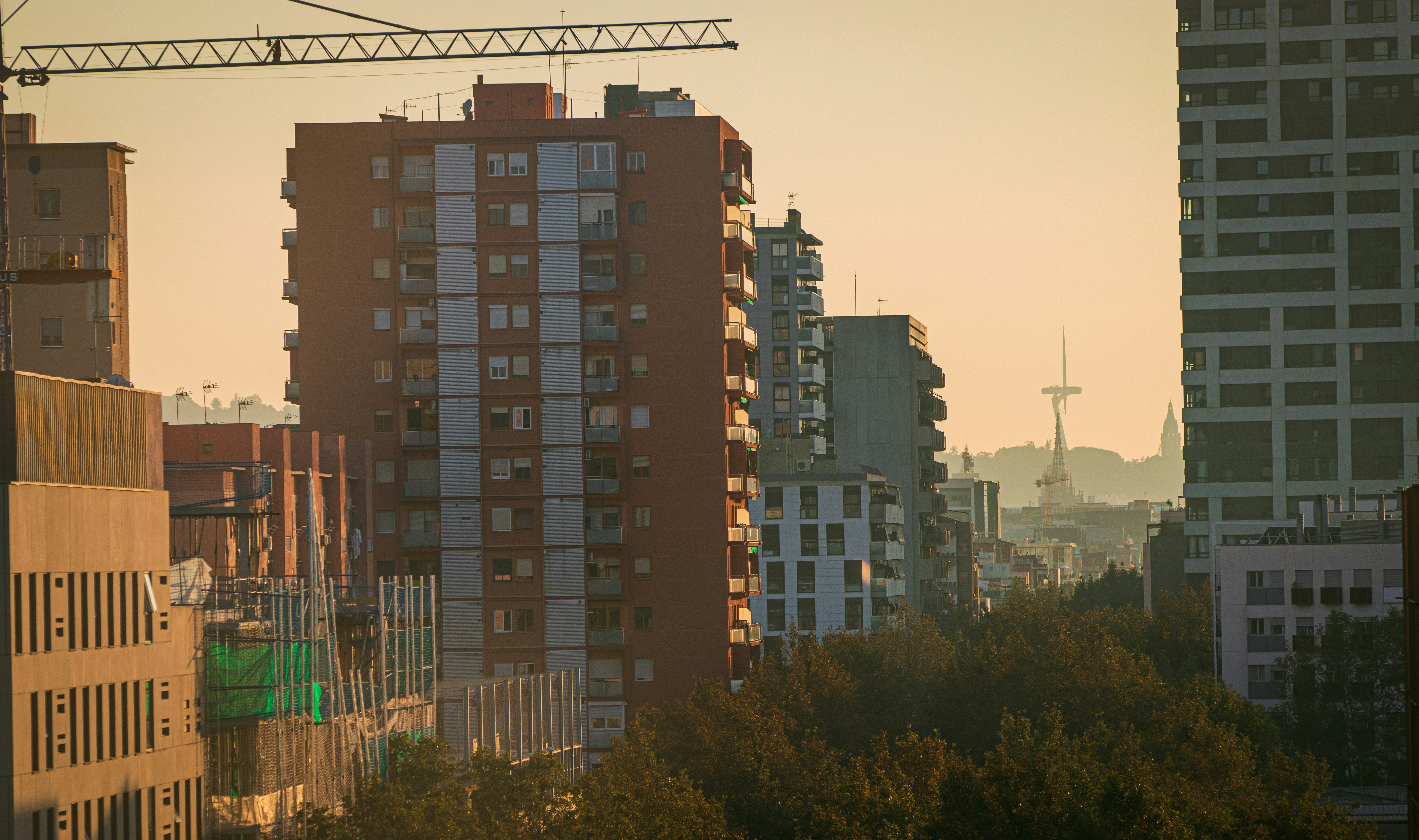 A city with tall buildings and a crane in the background
