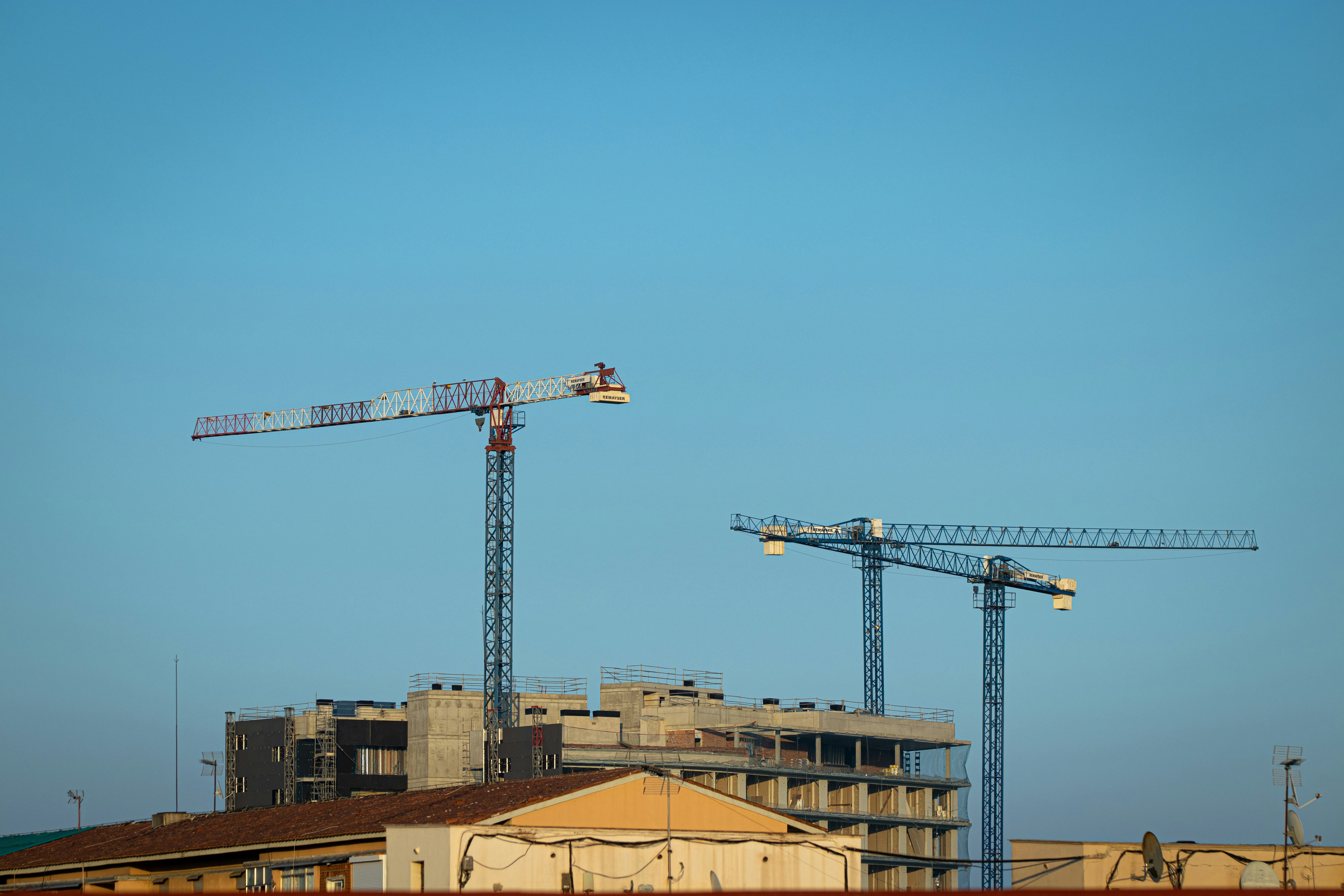 a couple of cranes that are on top of a building