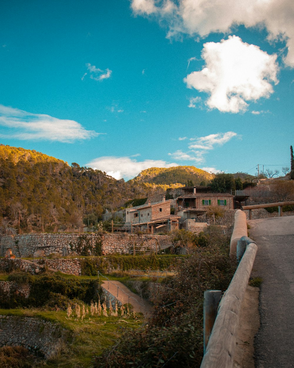 a scenic view of a town with mountains in the background