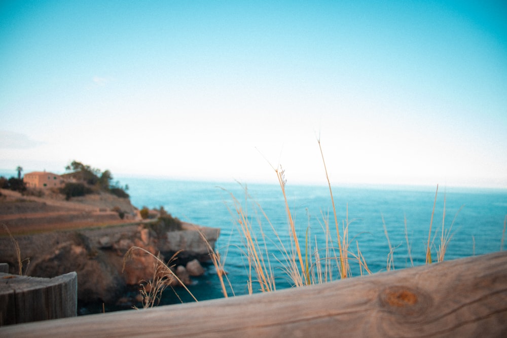 a view of the ocean from a wooden fence