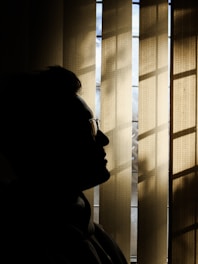 a silhouette of a man in front of a window