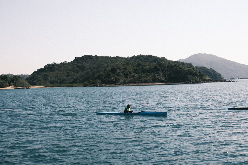 a person in a kayak in the middle of a body of water