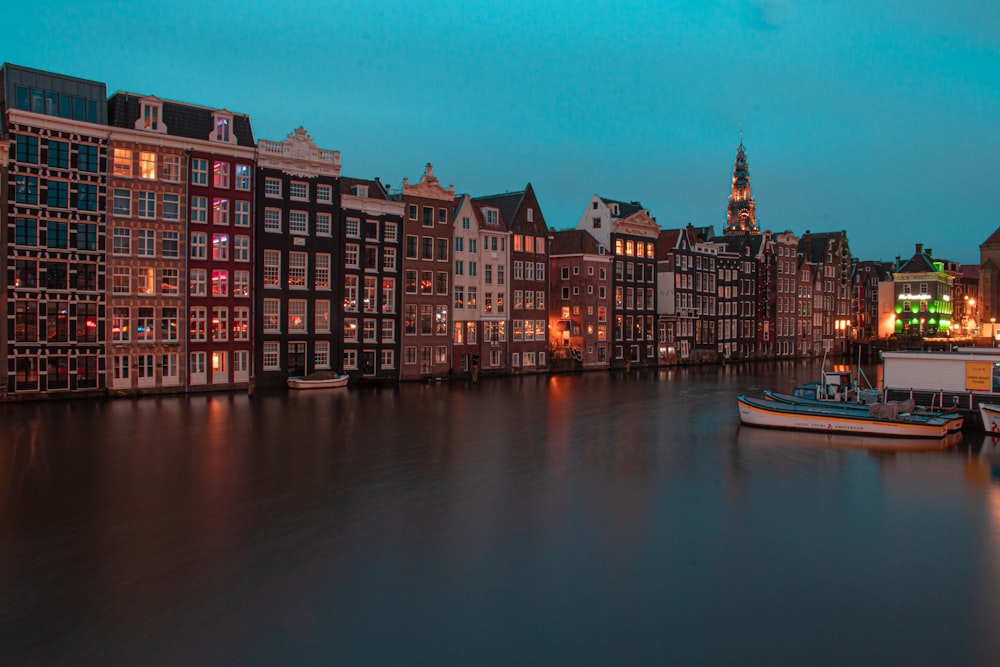 several boats are docked in a canal at night