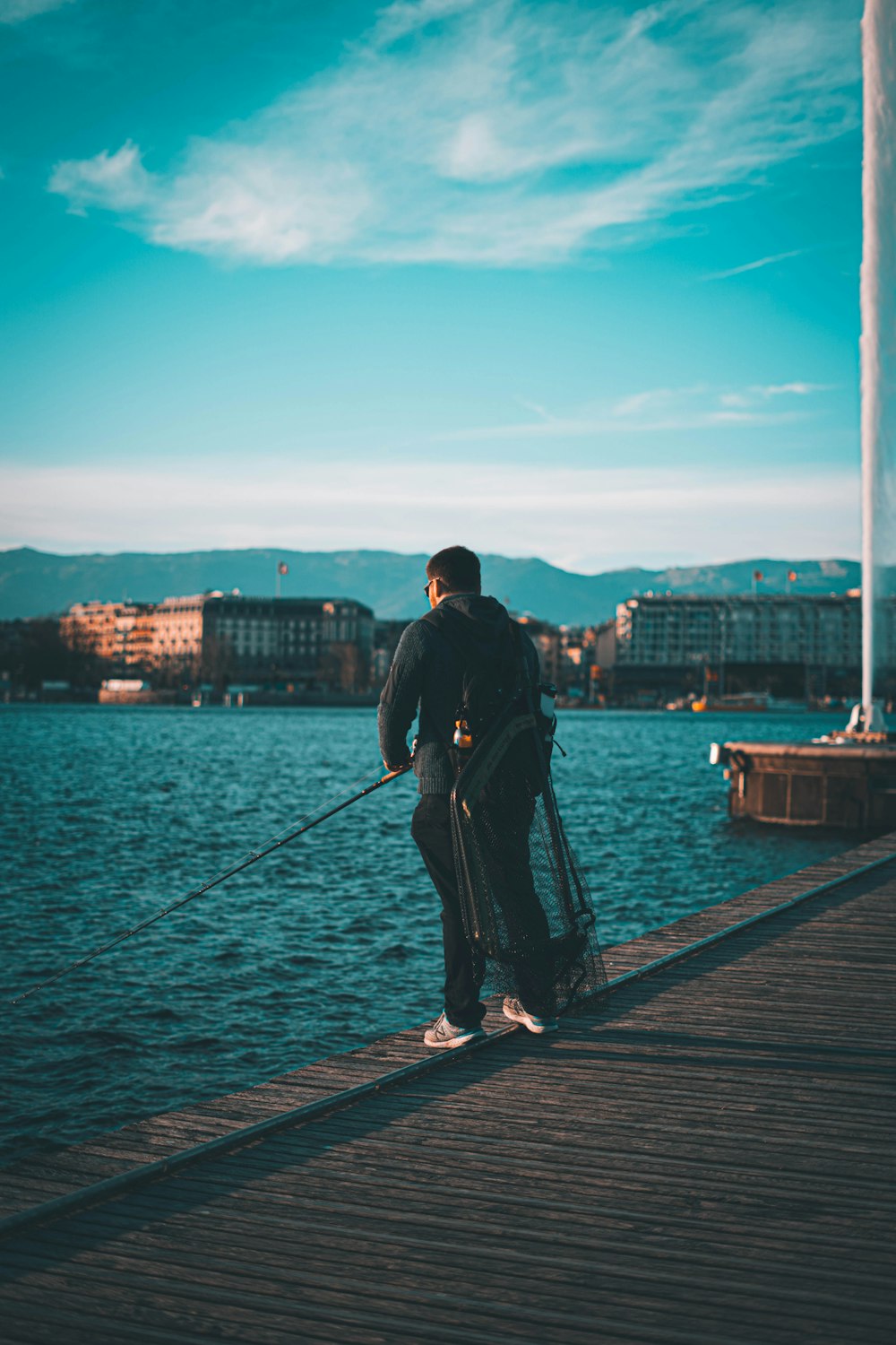 a man is standing on a dock with his luggage