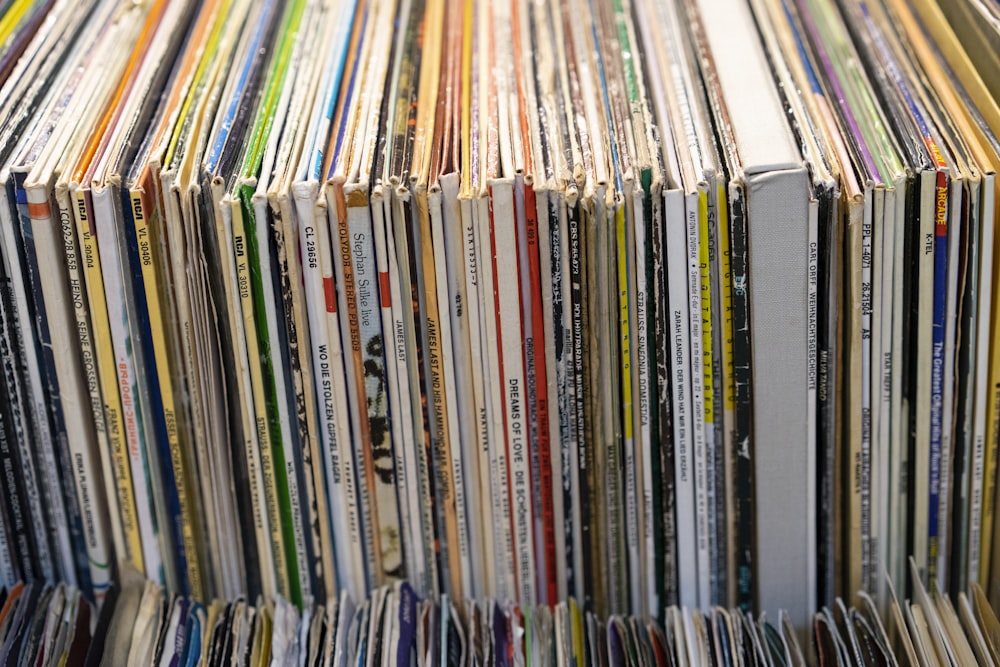 a large stack of records sitting on top of a table
