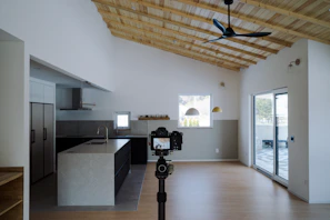 a room with a ceiling fan and a kitchen