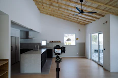 a room with a ceiling fan and a kitchen