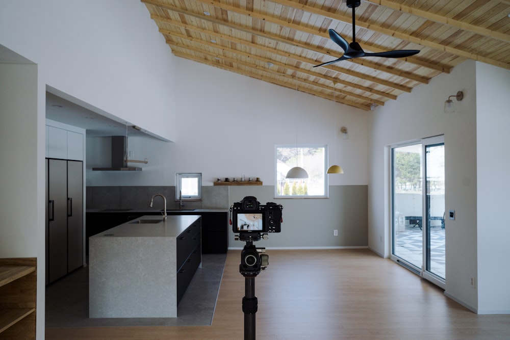 a room with a ceiling fan and a kitchen