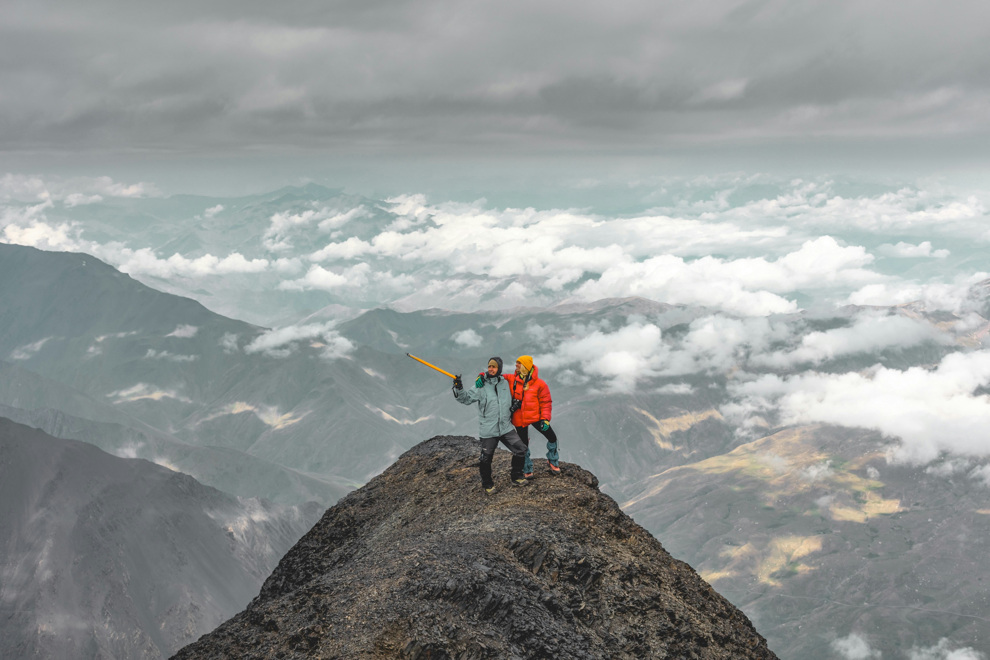 a man standing on top of a mountain with a telescope