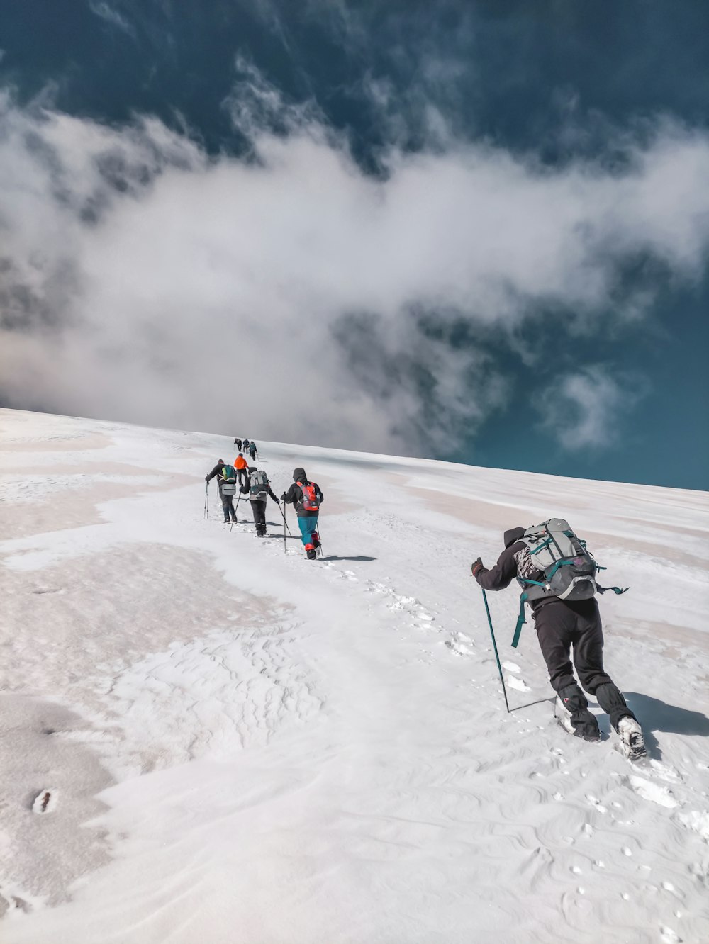 a group of people walking up a snow covered slope