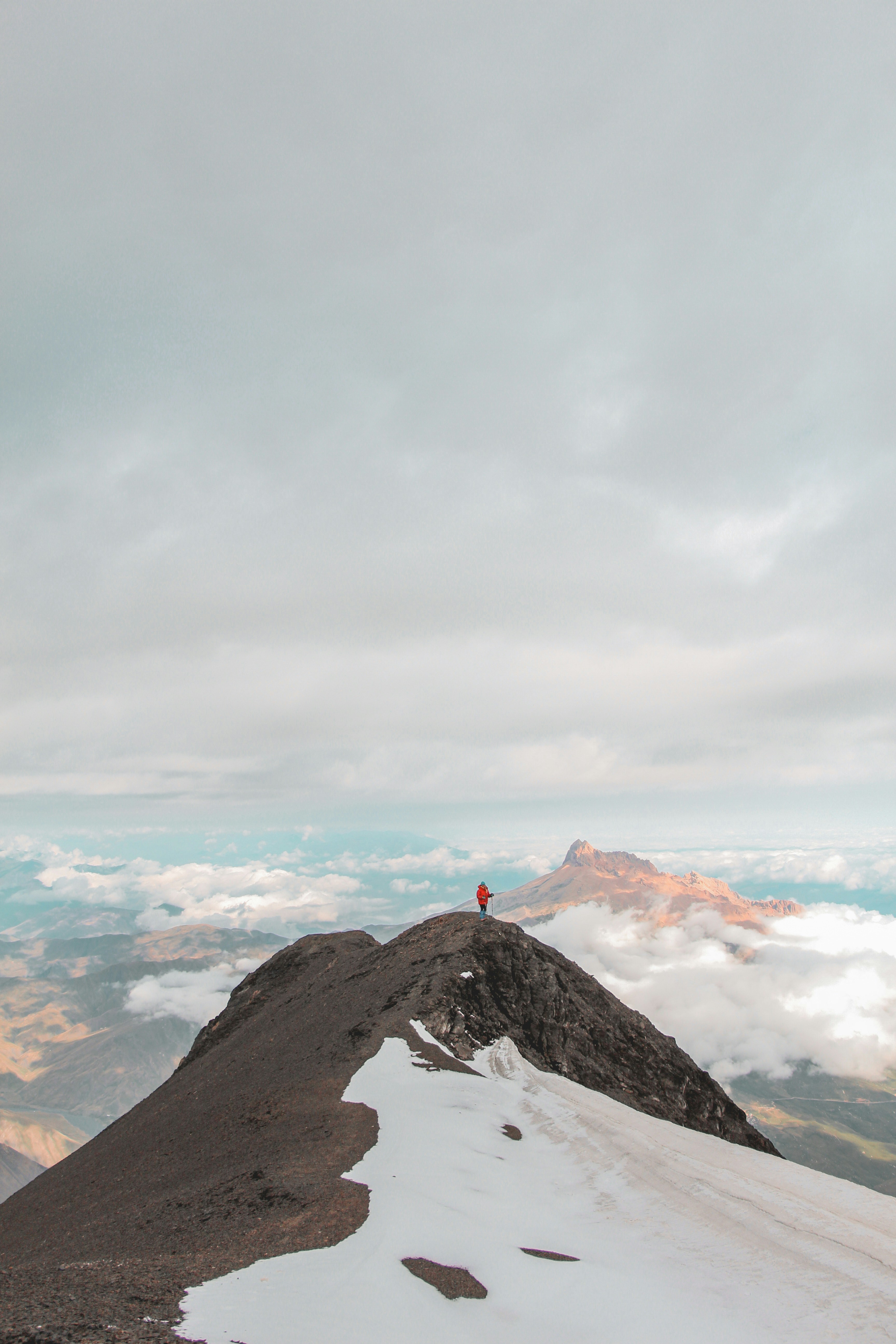 Mountaineer wearing orange GORE-TEX shell on snowy peak