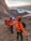 A group of hikers reaching the summit of Acatenango volcano at sunrise with vibrant sky colors.