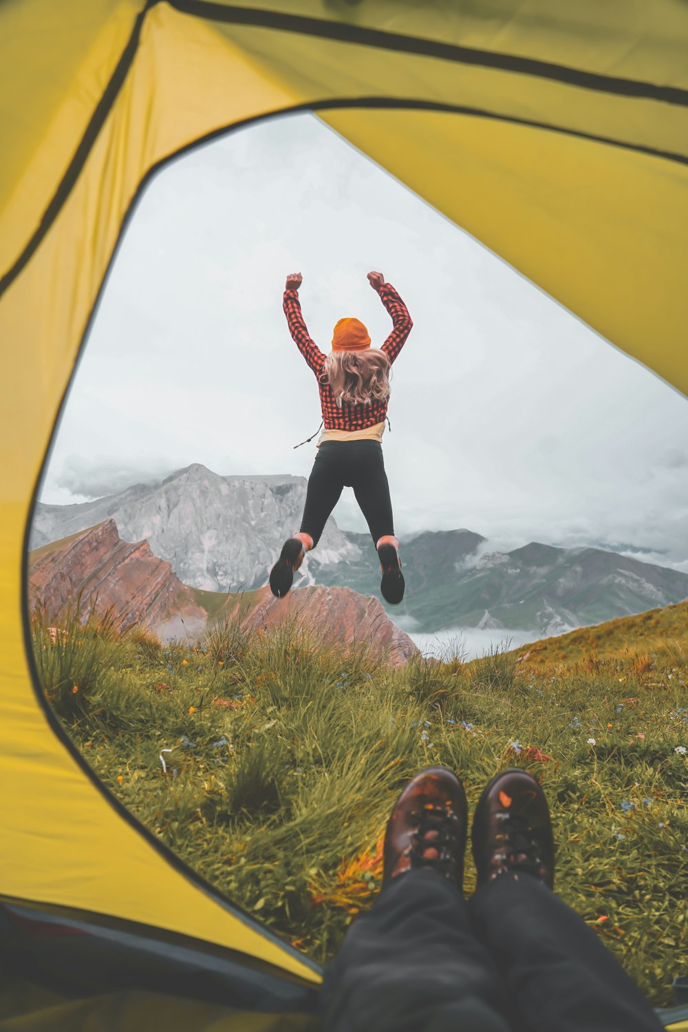 a person jumping in the air from a tent