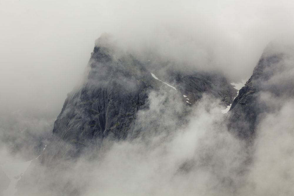 a mountain covered in fog and clouds on a cloudy day