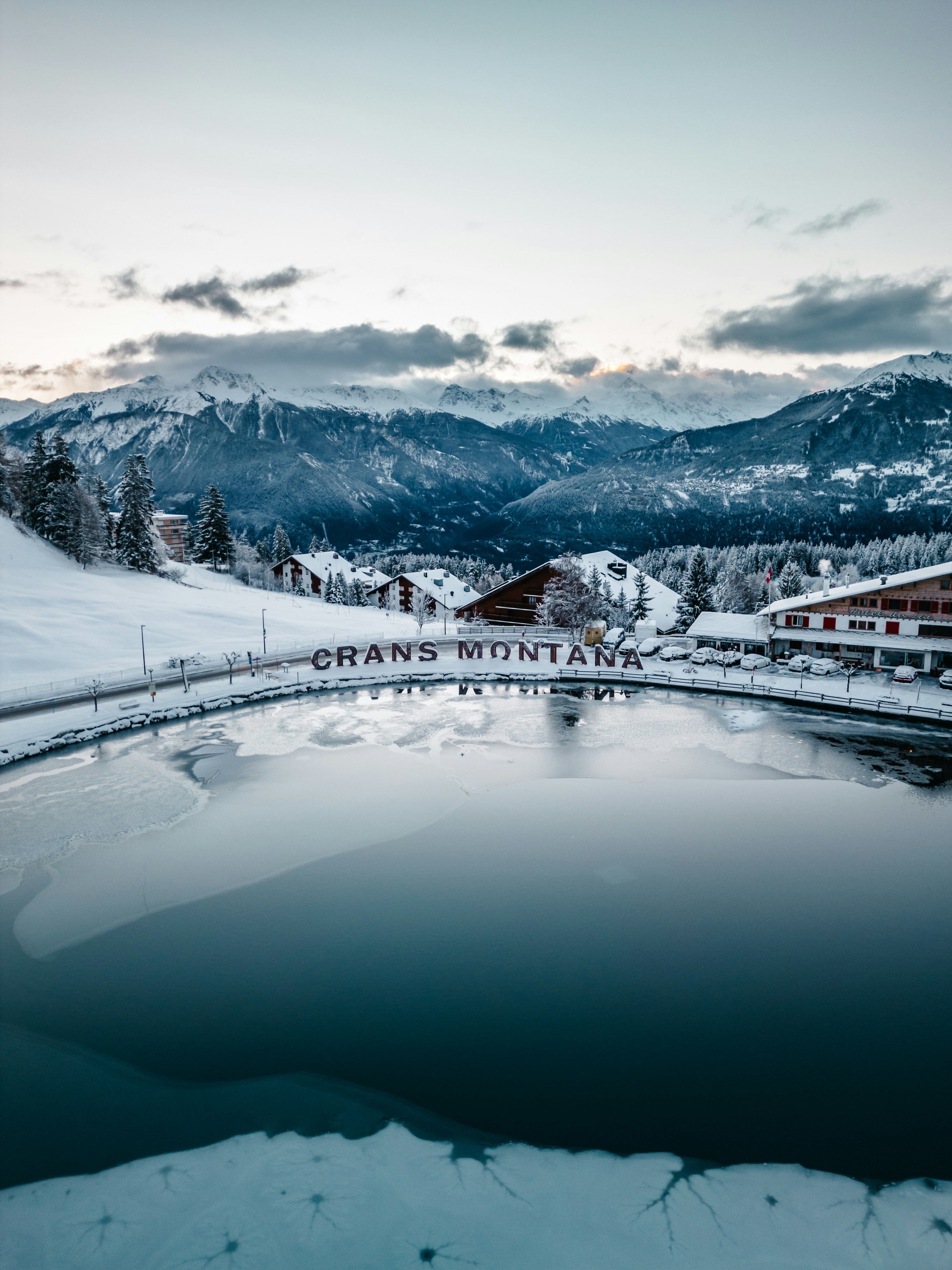 a lake surrounded by snow covered mountains