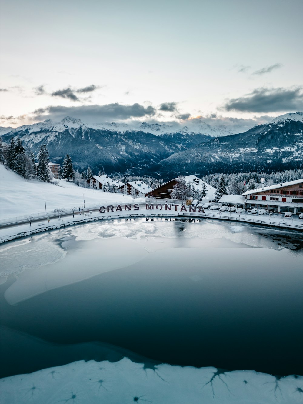 a lake surrounded by snow covered mountains