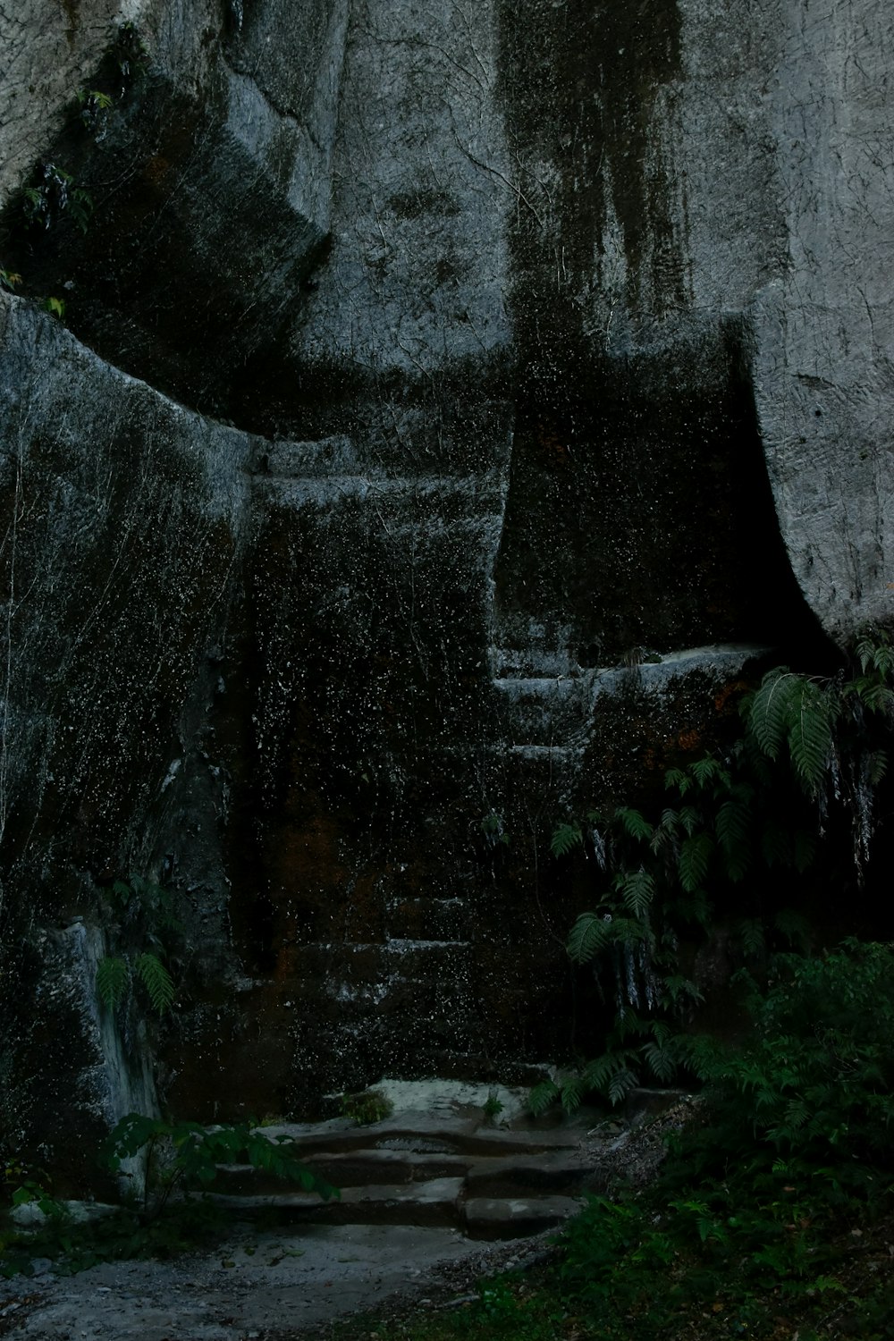 a man walking up a set of steps next to a waterfall