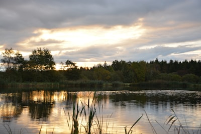 A sunset view over a tranquil lake in the countryside.