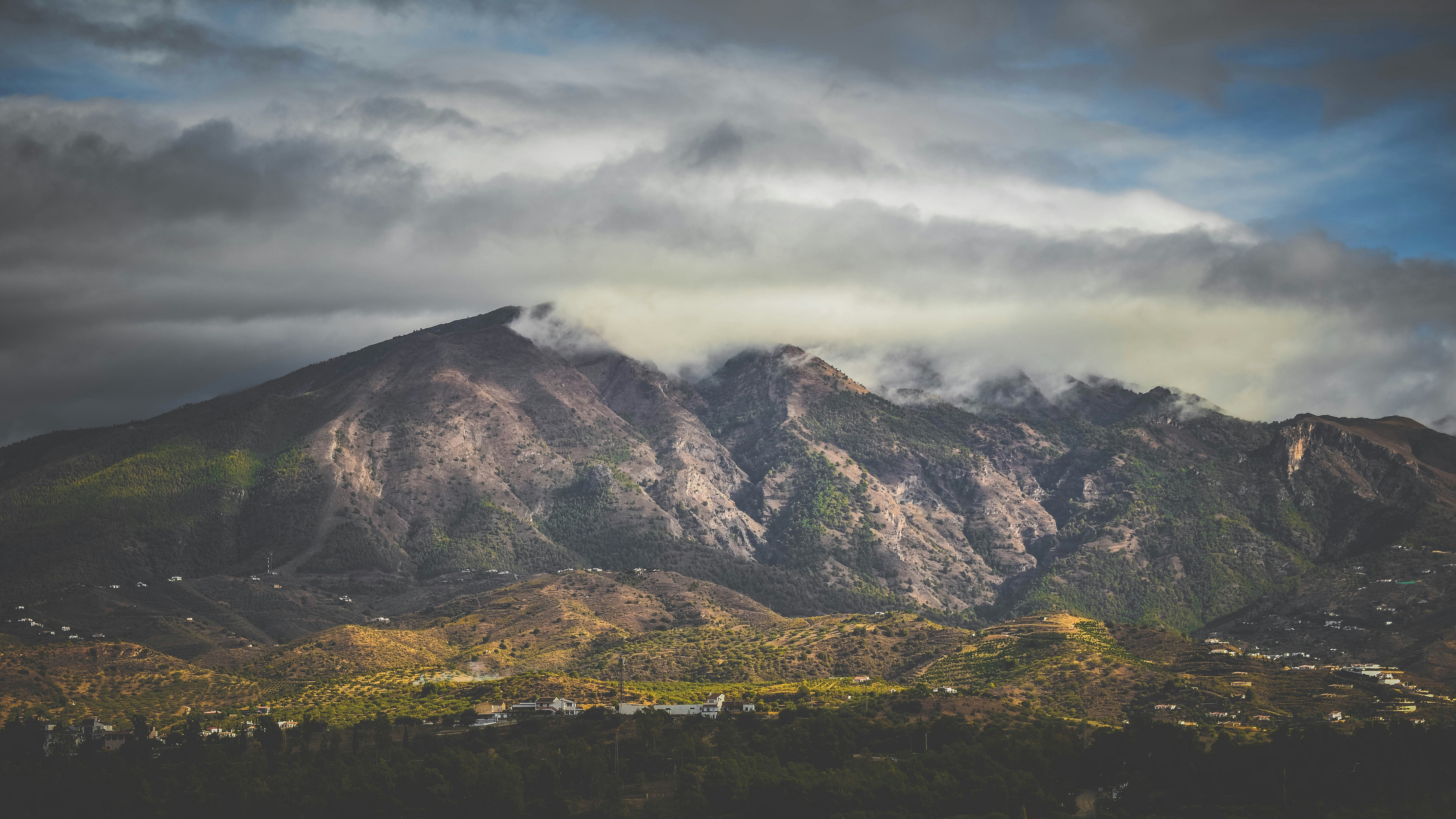 Una vista di una montagna con un cielo nuvoloso