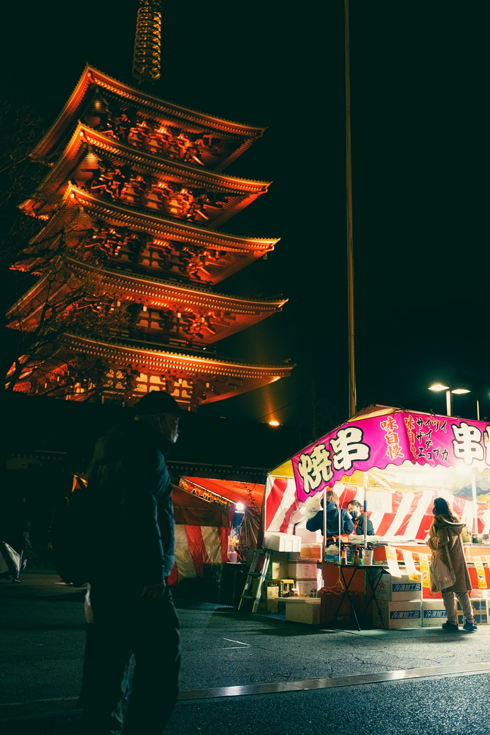 a fairground with people standing around it at night